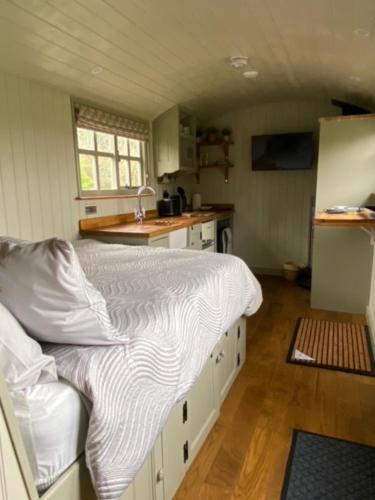 a bedroom with a large bed in a kitchen at Woodpecker Shepherds Hut in Boston