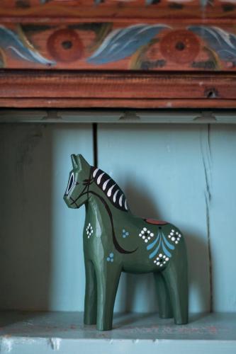 a green plastic horse statue sitting on a shelf at Fryksås Hotell & Gestgifveri in Fryksås