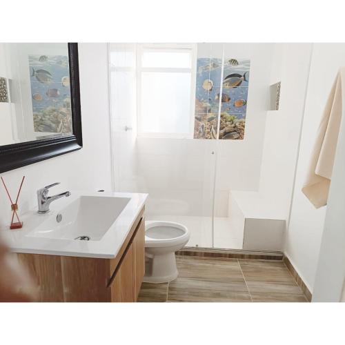 uma casa de banho branca com um lavatório e um WC em Posada Campestre en Doradal em Puerto Triunfo