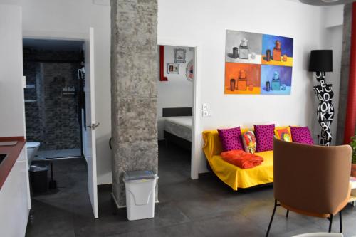 sala de estar con sofá amarillo y cama en Sevilla Urban Flat en Sevilla