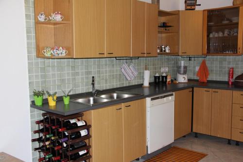 a kitchen with wooden cabinets and a sink and a counter at Casa Vacanze Margherita in Riola Sardo