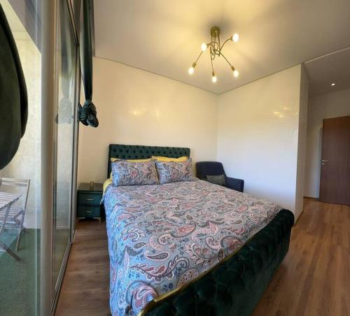 a bedroom with a large bed and a chandelier at Appartement à Marrakech (Piscine) in Marrakech