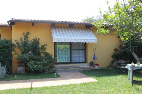 a yellow house with a porch and a window at Casa Vacanze Margherita in Riola Sardo