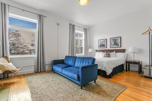 a bedroom with a bed and a blue chair and a blue couch at Library Square Suites in Toledo