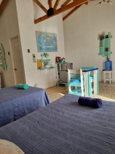 1 dormitorio con 2 camas y silla azul en Estudio Los Mosaicos, en Vicuña