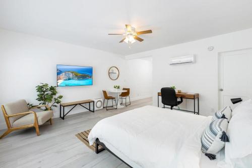 a white bedroom with a bed and a ceiling fan at Victoria Park Unique Studio close to Las Olas Blvd in Fort Lauderdale