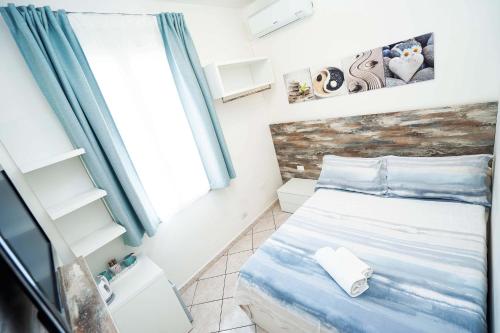 a small bedroom with a bed and a window at Taormina Beach House in Mazzeo