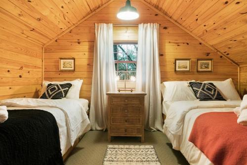 - une chambre avec 2 lits dans une cabane en bois dans l'établissement Pattersons Cabin-Nature Retreat-10 Mi to DT, à Garfield