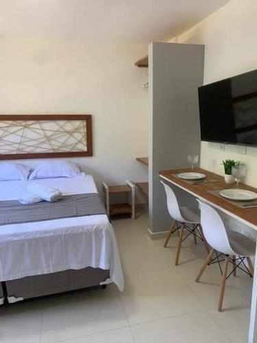 um quarto com uma cama, uma secretária e uma televisão em Doce Lar Hospedagem em Morro de são Paulo AP completo com cozinha em Cairu