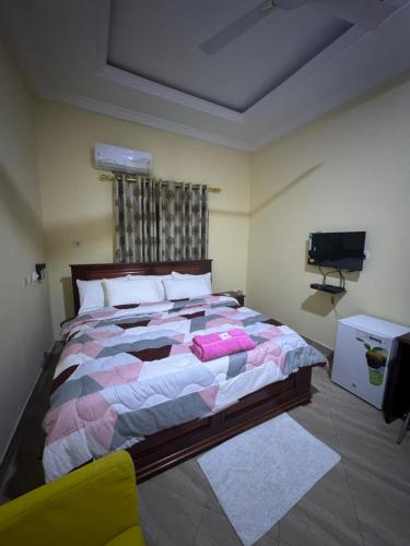 een slaapkamer met een groot bed en een televisie bij JOSBA HOTEL in Bechem