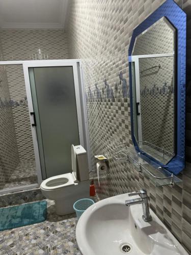 a bathroom with a toilet and a sink and a mirror at JOSBA HOTEL in Bechem