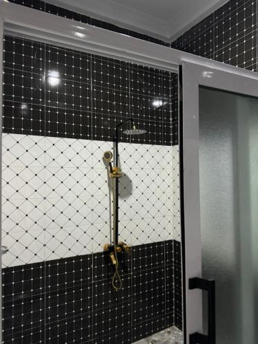 a black and white tiled bathroom with a shower at JOSBA HOTEL in Bechem