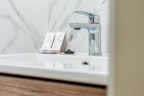 a bathroom sink with a faucet and a book at Silver Inn Hotel in Cerro Azul