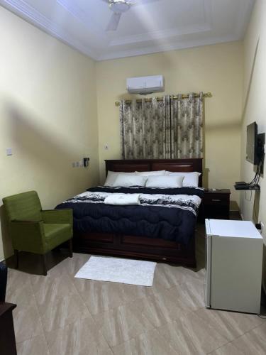 1 dormitorio con 1 cama y 1 silla verde en JOSBA HOTEL, en Bechem