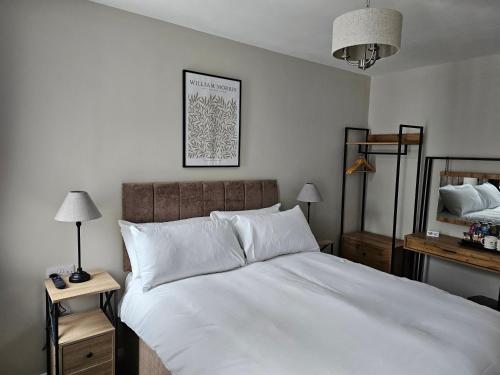 um quarto com uma grande cama branca e um espelho em The Ivernia hotel em Skegness