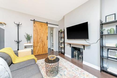 a living room with a couch and a tv at Cozy 1BR Apartment in Corso Italia in Toronto