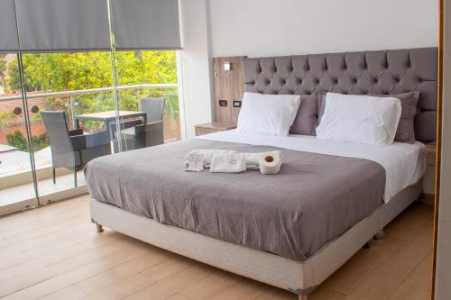 a bedroom with a large bed with two towels on it at Silver Inn Hotel in Cerro Azul