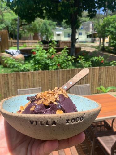 a person holding a bowl of food with a dessert at Villa Xodó in Fernando de Noronha