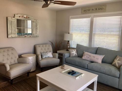 Una sala de estar con un sofá y sillas y una mesa. en New Ocean Block Duplex, en Beach Haven