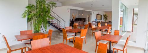 a restaurant with wooden tables and chairs and a staircase at Silver Inn Hotel in Cerro Azul