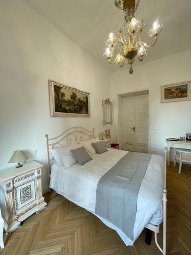 a bedroom with a large white bed and a chandelier at Stile Libero Guest House in Turin