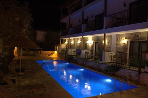 達特恰的住宿－Palamut Butik Otel，一座游泳池,在晚上在建筑物前