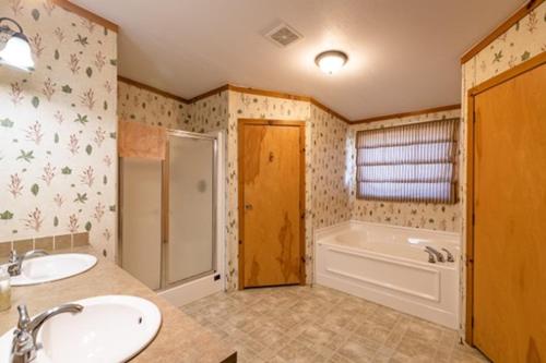 ein Badezimmer mit zwei Waschbecken, einer Badewanne und einer Dusche in der Unterkunft 6 Guests 3br, Fully Furnished, On-site Enjoyment in Neillsville