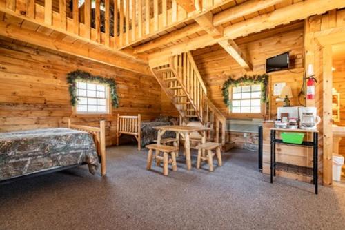 a bedroom with a staircase in a log cabin at Sleeps 7 Rustic Loft At Riviera Resort! in Neillsville