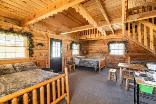 a bedroom in a log cabin with a bed and a desk at Sleeps 7 Rustic Loft At Riviera Resort! in Neillsville