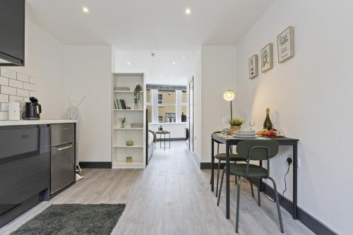 a kitchen and dining room with a table and chairs at The Olive Suite in Ilkeston