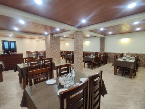 un restaurant avec des tables et des chaises dans une salle dans l'établissement Keswani Group Tashi Heritage Hotel & Resort, à Gangtok