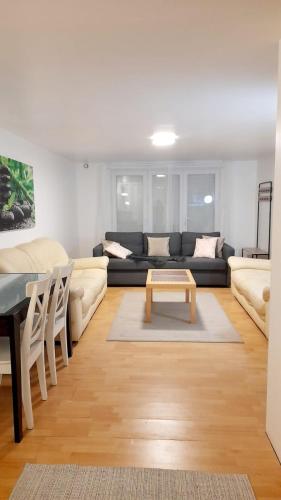 un salon avec un canapé et une table dans l'établissement Grand Studio Indépendant à 30 minutes de Paris (RDC d'un pavillon) dans village bord de Seine, à La Frette-sur-Seine