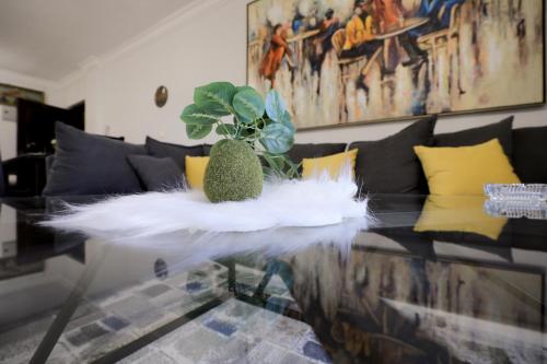 a living room with a glass table with a plant on it at Cozy apartment New Cairo in New cairo
