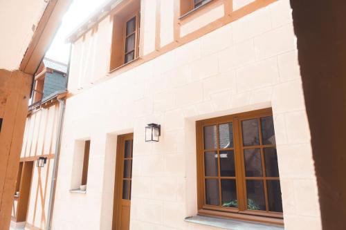 a white brick building with windows on a street at Le Colimaçon in Tours