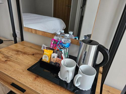 a table with a coffee maker and cups on it at The Ivernia hotel in Skegness