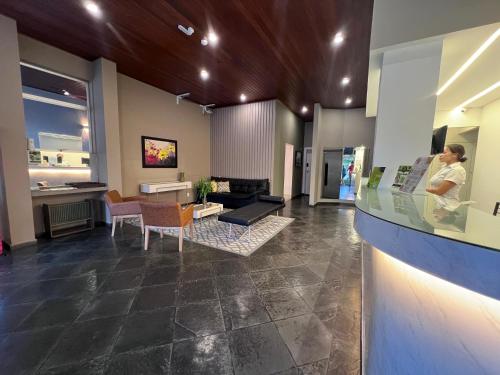 a woman is standing in a room with a lobby at Regis Hotel II in Registro