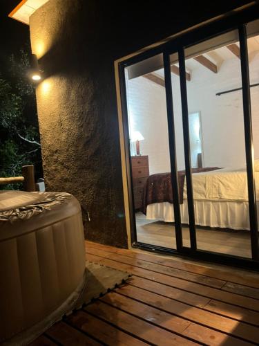 a room with a large glass door leading to a bedroom at La Luna, casa mágica en sierras! in Villa Serrana