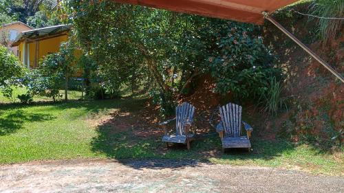 duas cadeiras azuis sentadas debaixo de uma tenda num quintal em Pousada Casa da montanha em Casimiro de Abreu