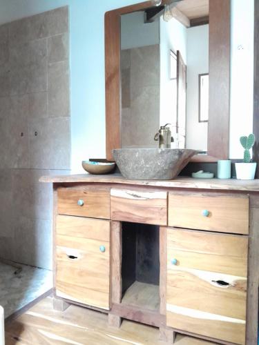 W łazience znajduje się umywalka i lustro. w obiekcie Ti Kaz Kafé - Charmante Case créole indépendante à St Leu w mieście Saint-Leu