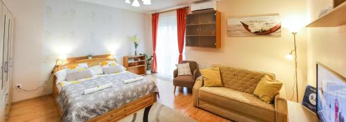 a bedroom with a bed and a couch at Dia Apartman in Miskolc