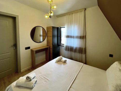 a bedroom with a bed with two towels on it at Qafqaz Gabala Twin A Frame Villas in Gabala