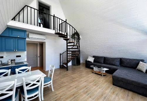 a living room with a black couch and a staircase at Qafqaz Gabala Twin A Frame Villas in Gabala