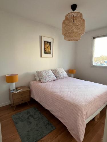sypialnia z łóżkiem, lampką i oknem w obiekcie Appartement 2 pièces Bois d’Arcy w mieście Bois-dʼArcy
