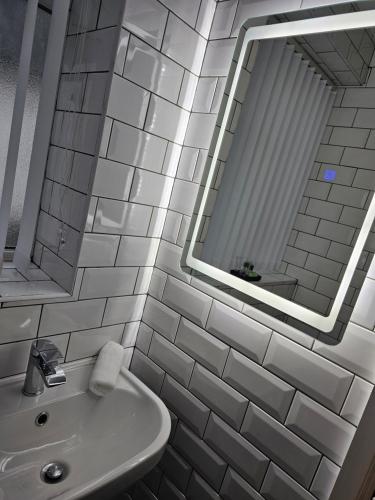 a white bathroom with a sink and a mirror at The Ivernia hotel in Skegness