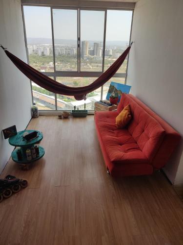 卡塔赫納的住宿－Apartamento compartido cartagena de indias，客厅设有一张红色的沙发,配有大窗户