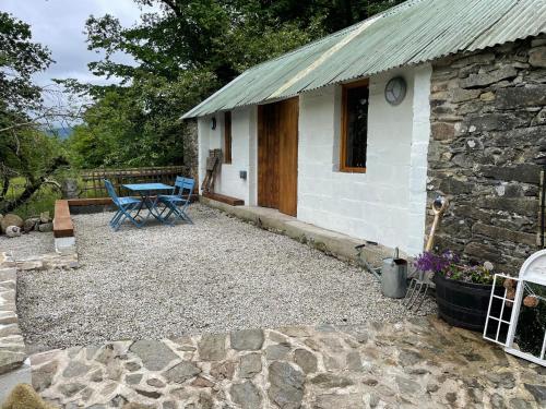 a small stone house with a table and a picnic table at Glamping at The Old Rectory in Dún Ard