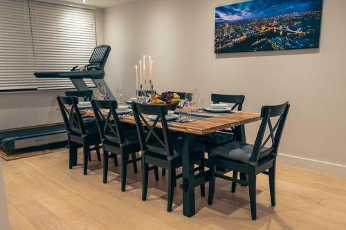 a dining room table with black chairs and a dining room at Luxurious 4 Bedroom with patio in Edgware