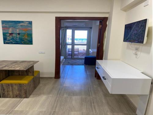 Habitación con escritorio blanco y mesa. en Princess Resort en Hurghada