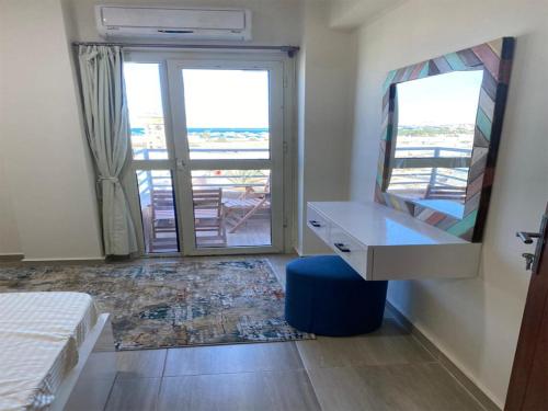 a bedroom with a desk and a view of a balcony at Princess Resort in Hurghada