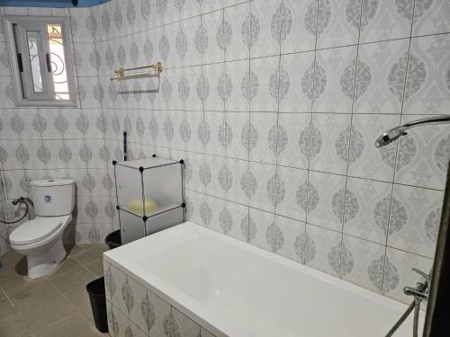 a bathroom with a toilet and a bath tub at Villa L'Oasis in Ouagadougou